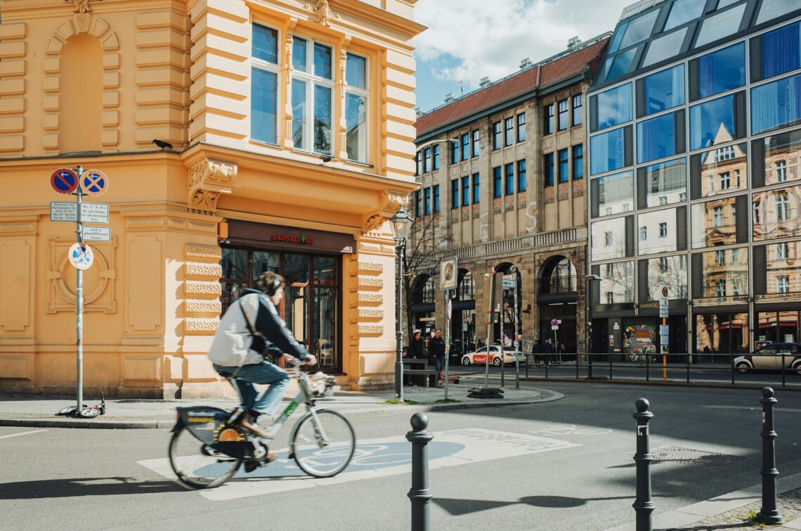 A cyclist rides in a city with stunning architecture.