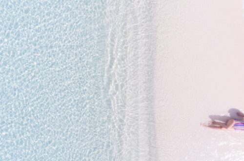 aerial view photography of woman sunbathing on seashore