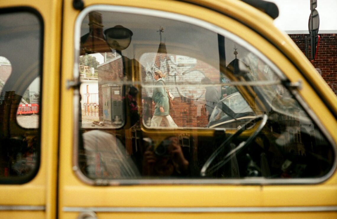 A yellow car's interior is seen through a window.