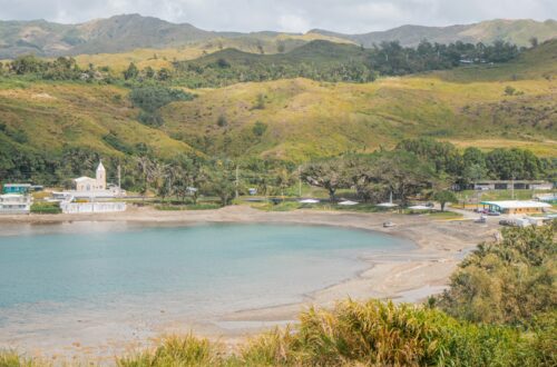 a body of water surrounded by lush green hills