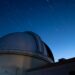 Observatory dome under a starry night sky.